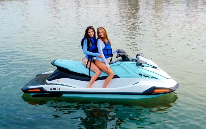 Two riders on a jet ski near the Chicago skyline.